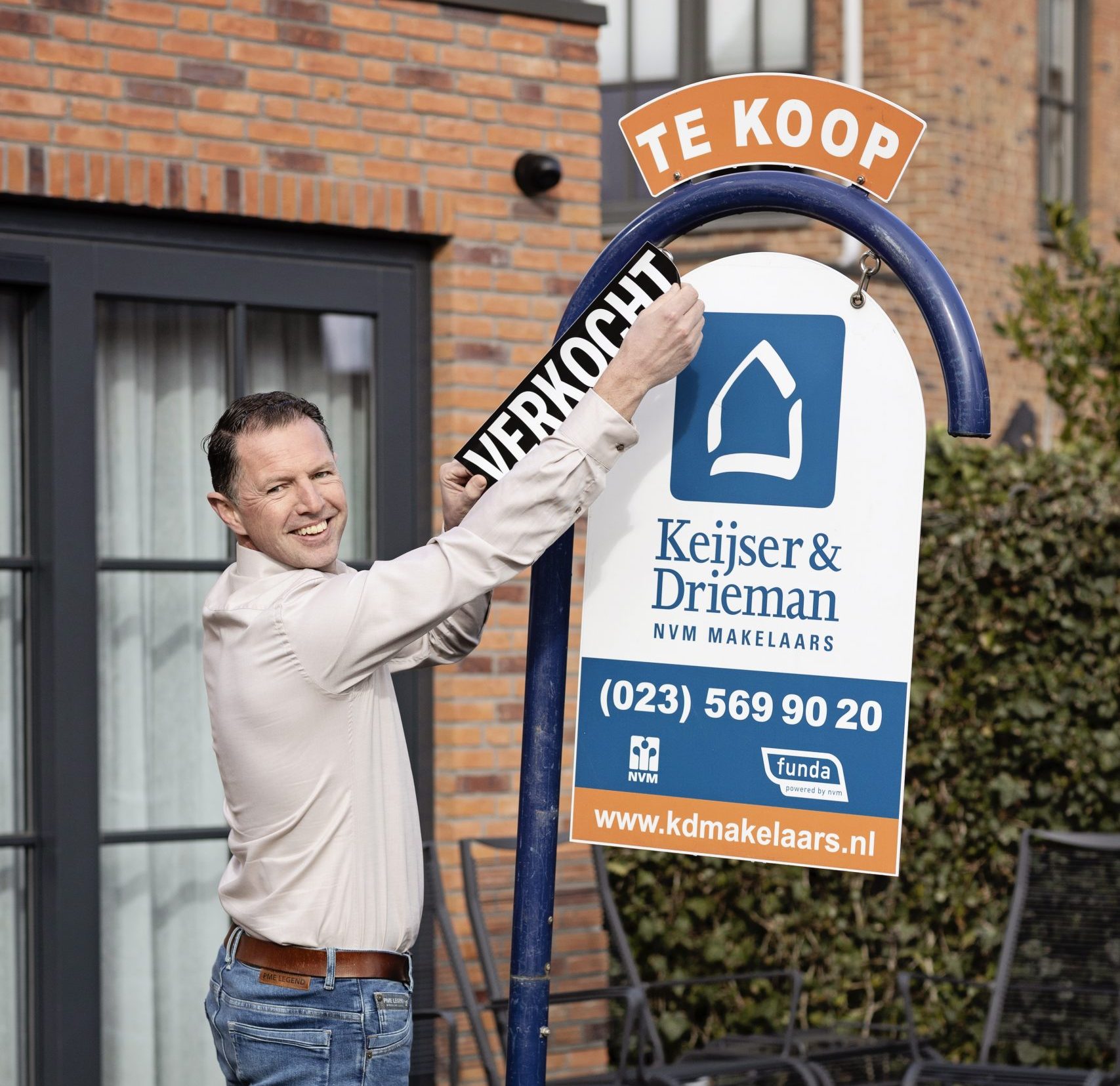 Siem van Keijser & Drieman Makelaars Hoofddorp met een te koop bord en verkocht sticker in een voortuin